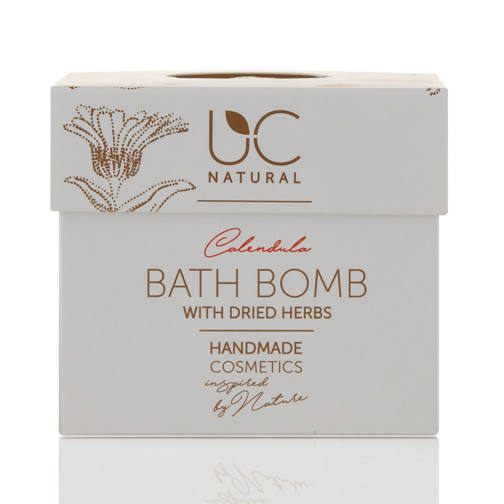 Verpakkingsdoos van de Calendula bruisbal van UC Naturals. De doos is wit met bruine tekst en bloemen. De foto heeft een witte achtergrond.