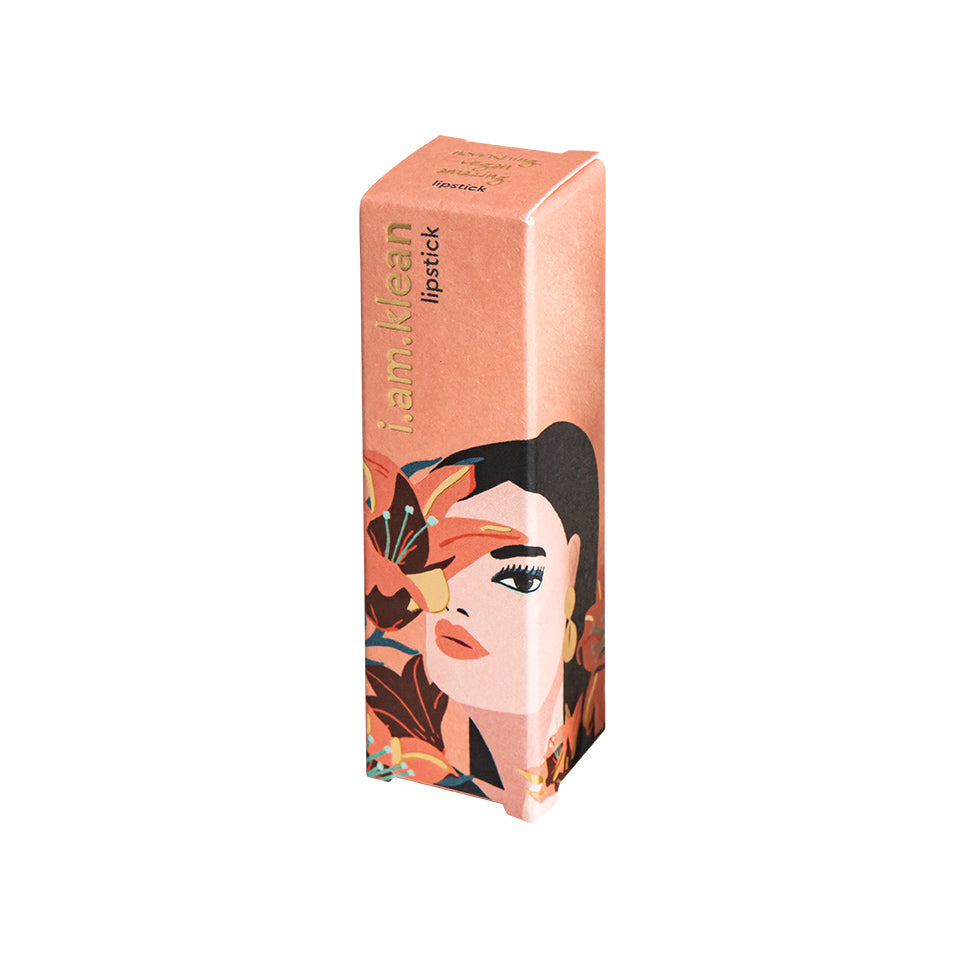 Gesloten verpakkingsdoos van de nectar lippenstift van i.am.klean. Op de doos staat een artistiek getekende vrouw die bloemen vasthoudt. De foto heeft een witte achtergrond.