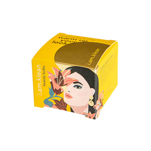 Gele verpakking van de Sunkissed Beauty Bulbs van i.am.klean. De kartonnen doos is artistiek vormgegeven met een vrouw en bloem als tekening.